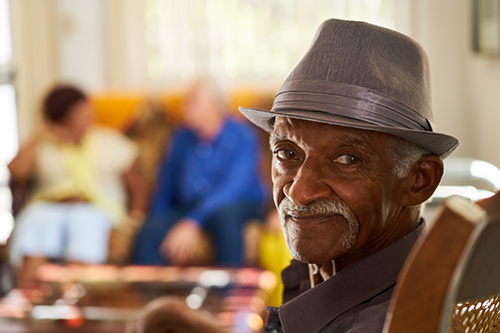 Retired black man wearing hat looking at viewer